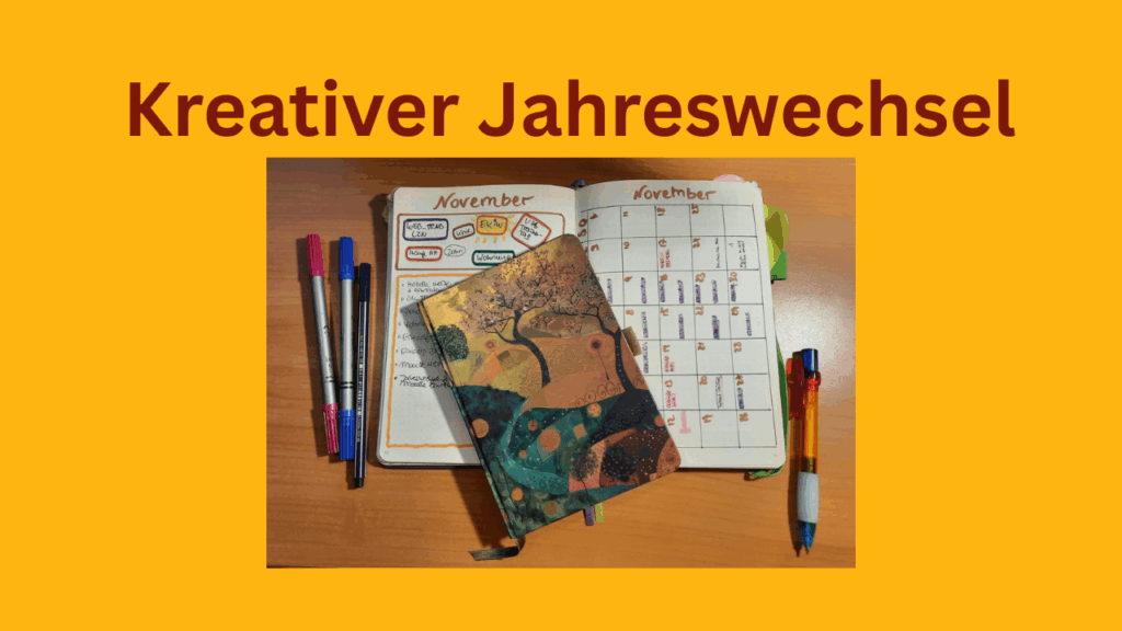Kreativer Jahreswechsel, ein Notizbuch liegt aufgeschlagen auf einem Tisch, ein Kalender und bunte Stifte.