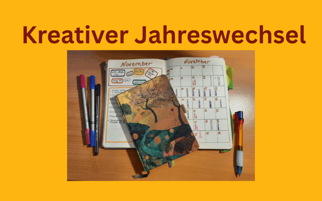 Kreativer Jahreswechsel, ein Notizbuch liegt aufgeschlagen auf einem Tisch, ein Kalender und bunte Stifte.